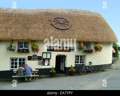 Vista esterna della ruota Inn public house con il giovane seduto fuori Tresillian vicino a Truro Carrick Mid Cornwall South West en Foto Stock