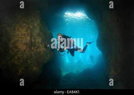 Subacqueo con fotocamera cercando nella caverna. Mare di Bohol, Filippine, Sud-est asiatico Foto Stock