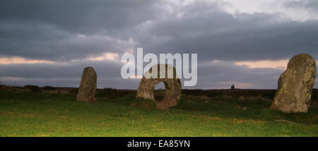 Gli uomini un Tol Neolitico pietre Permanente & Ding Dong la mia casa motore silhouette al tramonto Bosullow vicino a Penwith Morvah Cornwa ovest Foto Stock
