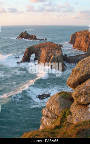 Vista da Carn allietare al tramonto attraverso Zawn pozzetti per le isole rocciose di Enys Dodnan e il Cavaliere armato & Carn Greeb scogliere La Foto Stock