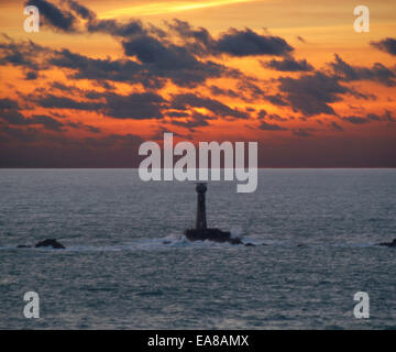 Tramonto spettacolare sopra il faro Longships Lands End Penwith West Cornwall South West England Regno Unito Foto Stock