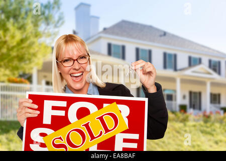 Excited donna tenendo le chiavi di casa e venduto beni immobili segno davanti di Nizza nuova casa. Foto Stock