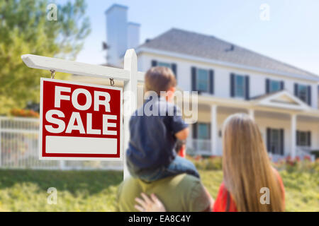 Curioso famiglia rivolta per la vendita immobiliare di segno e bella casa di nuova costruzione. Foto Stock