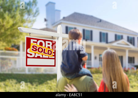 Curioso rivolto verso la famiglia venduto per la vendita immobiliare di segno e bella casa di nuova costruzione. Foto Stock