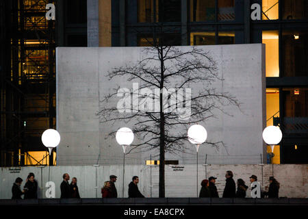 Berlino, Germania. 8 Novembre, 2014. Ai visitatori di visualizzare un'installazione luminosa di palloncini lungo il corso del muro di Berlino in un Memoriale del Muro di Berlino sito a Berlino, Germania, il 9 novembre 8, 2014. Alcuni 8000 bianco luminoso palloncini erano fissati a Berlino da nov. Da 7 a 9 per commemorare il venticinquesimo anniversario della caduta del muro di Berlino. Credito: Zhang ventola/Xinhua/Alamy Live News Foto Stock