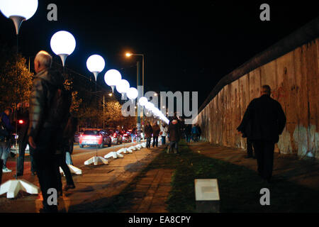 Berlino, Germania. 8 Novembre, 2014. Ai visitatori di visualizzare un'installazione luminosa di palloncini lungo il corso del muro di Berlino in un Memoriale del Muro di Berlino sito a Berlino, Germania, il 9 novembre 8, 2014. Alcuni 8000 bianco luminoso palloncini erano fissati a Berlino da nov. Da 7 a 9 per commemorare il venticinquesimo anniversario della caduta del muro di Berlino. Credito: Zhang ventola/Xinhua/Alamy Live News Foto Stock