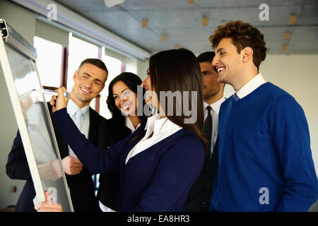 Happy business team con flip board in ufficio Foto Stock