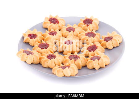Biscotti dolci con marmellata su lastra grigia isolati su sfondo bianco. Foto Stock