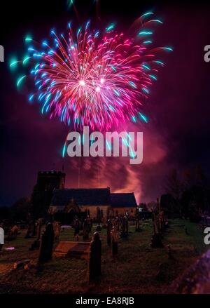 Il falò corteo per ricordo. Spettatori rivestite le strade della East Sussex villaggio di east hoathly nelle vicinanze del Lewes la scorsa notte per guardare i banner di fuoco portato variopinto come un atto di ricordo in rotta per una grande scultura in legno falò e fuochi d'artificio. Il carnevale la società ha commemorato paesani caduti nella prima e nella seconda guerra mondiale per gli ultimi 90 anni. Fuochi d'artificio ant la fine della serata al di sopra della chiesa parrocchiale. Foto Stock