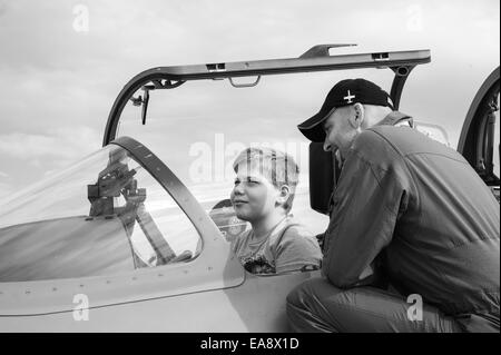 Un giovane ragazzo viene mostrato un ceco air force Aero L-159 Alca multi-ruolo aeromobile presso il Malta International Airshow 2014 Foto Stock