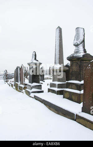 Coperta di neve lapidi e monumenti in un cimitero di collina in Charlesworth vicino a Glossop, Derbyshire. Foto Stock