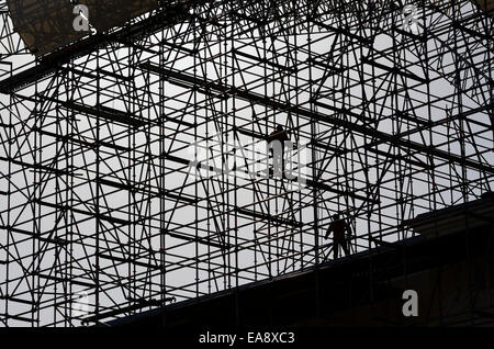 Lavoratori assemblare costruzioni di metallo sul cielo blu sullo sfondo Foto Stock