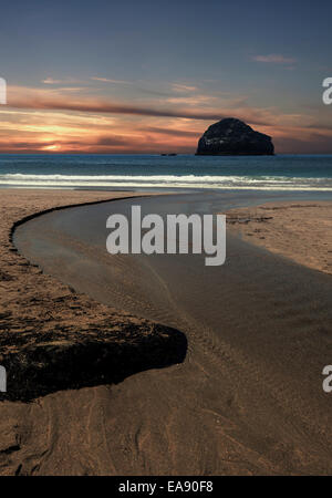 Trebarwith Strand vicino a Tintagel, Cornwall, con Gull Rock in silhouette. Simulazione del tramonto. Foto Stock