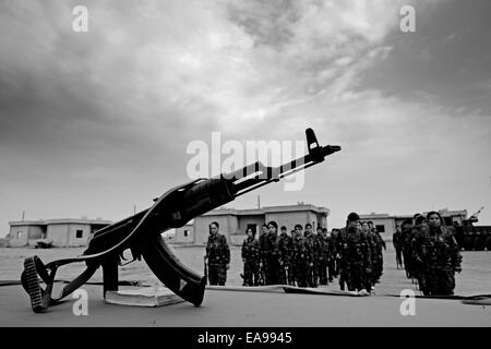 Un fucile Kalashnikov ak-47 posto su un tavolo durante il giuramento Cerimonia dei combattenti curdi delle unità di protezione delle donne YPJ In un campo di addestramento in al Hasakah o distretto di Hassakeh Nel nord della Siria Foto Stock