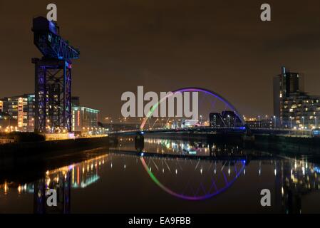 Il fiume Clyde a Glasgow con l'Arco (ponte di squinty) e gru illuminate per celebrare il MTV EMA all'arena SSE Hydro Foto Stock