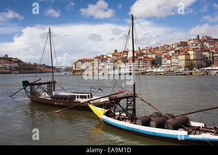 Città di Porto in Portogallo. Rabelo Portoghesi tradizionali imbarcazioni da carico con porta botti da vino sul fiume Douro e vecchi lo skyline della citta'. Foto Stock