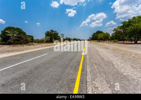 Strada infinita in Namibia, Caprivi Game Park, con cielo blu Foto Stock