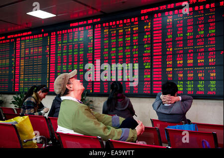 Hefei, cinese della provincia di Anhui. Decimo Nov, 2014. Gli investitori verificare le scorte in una sala di trading di titoli di una società a Hefei, a est della capitale cinese della provincia di Anhui, nov. 10, 2014. Della Cina di Shanghai benchmark indice composito su Shanghai Borsa chiusa in corrispondenza di punti 2,473.67 lunedì fino 2.3 percento o 55,5 punti. © Du Yu/Xinhua/Alamy Live News Foto Stock