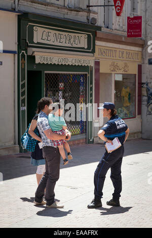 Femmina di Polizia Municipale ufficiale parla di famiglia sulla città francese street Foto Stock