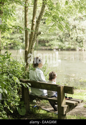 Donna e bambino seduto su una panchina. Foto Stock