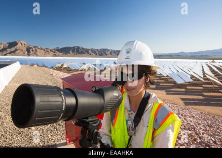 Andrea Wuenschel, uno dei 50 biologi lavorando al Ivanpah Solar Thermal Power Plant in California''s Deserto Mojave è attualmente il più grande impianto solare termico nel mondo. Esso genera 392 megawatt (MW) e distribuisce 173,500 heliostats che riflettono i raggi suns su tre torri solare. Esso copre 4.000 acri di deserto. Andrea è guardare fuori per gli uccelli che potrebbero essere battenti vicino alle torri solare. Foto Stock