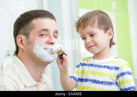 Preschooler guardando la rasatura del suo papà Foto Stock