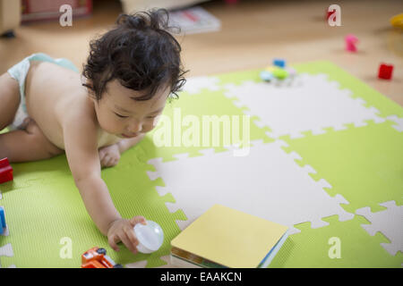 Baby boy giocando in ambienti chiusi. Foto Stock