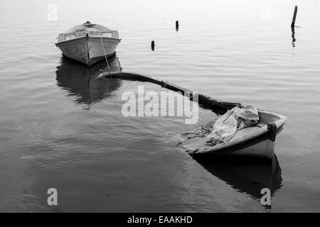 Sunken barca da pesca la riflessione sul lago in bianco e nero Foto Stock