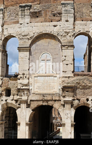 Un religioso lapide sulla parete esterna del Colosseo iconica nella città di Roma, Italia. Foto Stock