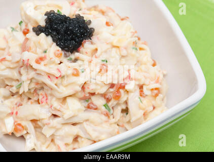 Insalata con maionese in un recipiente su un panno verde Foto Stock