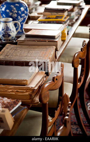 Vecchi libri su un tavolo con sedie. Foto Stock