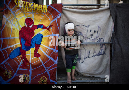 Striscia di Gaza, Al-Shejaiya quartiere. 9 Nov, 2014. Un bambino palestinese Abu Uday Aaasr, 4, si erge sopra le macerie della sua casa distrutta nel quartiere Al-Shejaiya, a est di Gaza City il 9 novembre 9, 2014. Bambini palestinesi ha superato un tempo duro durante la 50-giorno operazione israeliana nella Striscia di Gaza di questa estate. Oltre 500 bambini sono stati uccisi nella Striscia di Gaza e 3.000 feriti. Ci sono più di 40.000 famiglie rimaste sfollate. Il conflitto aveva lasciato 1.500 orfano. © Wissam Nassar/Xinhua/Alamy Live News Foto Stock