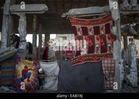 Striscia di Gaza, Al-Shejaiya quartiere. 9 Nov, 2014. Una ragazza palestinese Hiba Khalaf, 9, si erge sopra le macerie della sua casa distrutta nel quartiere Al-Shejaiya, a est di Gaza City il 9 novembre 9, 2014. Bambini palestinesi ha superato un tempo duro durante la 50-dayIsraeli operazione nella Striscia di Gaza di questa estate. Oltre 500 bambini sono stati uccisi nella Striscia di Gaza e 3.000 feriti. Ci sono più di 40.000 famiglie rimaste sfollate. Il conflitto aveva lasciato 1.500 orfani. © Wissam Nassar/Xinhua/Alamy Live News Foto Stock