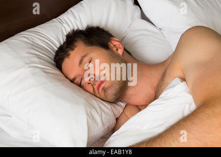 Un uomo dorme nel letto la mattina Foto Stock