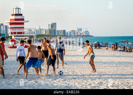 Miami Beach Florida,sabbia,stazione di bagnino a forma di faro,Oceano Atlantico,acqua,sabbia,uomo ispanico maschio,teen teen teen ager ragazzo giocare Foto Stock