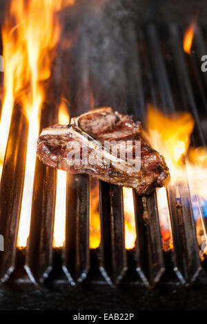 Deliziosa e succosa bistecca con l'osso su un barbecue in fiamme Foto Stock