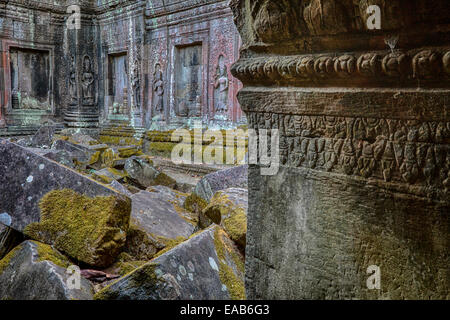 Cambogia. Ta Prohm rovine di templi, 12th-13th. Secolo. Devatas (divinità) Linea la parete di un cortile interno in rovine. Foto Stock