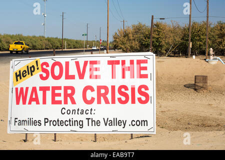 Un segno di agricoltori circa la crisi dell'acqua successivo di un 4 anno lunga siccità, vicino a Bakersfield nella valle centrale, California, Stati Uniti d'America, con il terreno trasformato in polvere. Tutta la California è in una catastrofica siccità con 2.2 miliardi di dollari persi ogni anno dal settore agricolo, con molti lavoratori licenziati. Un terzo dei bambini in California attualmente andare a letto affamati. 428,000 acri di terreno sono stati presi al di fuori della produzione nella valle centrale a causa della siccità. Foto Stock