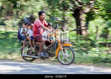 Cambogia. La sicurezza del traffico: uomo e quattro bambini su una moto senza casco. Foto Stock