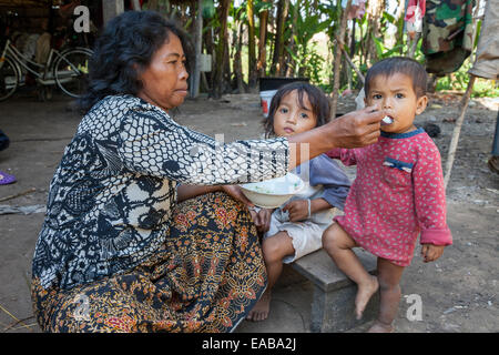 Cambogia. Madre cambogiano alimentando il pranzo per i suoi figli. Foto Stock