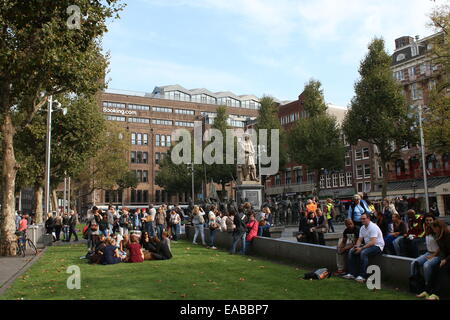 Rembrandtplein, interna della città di Amsterdam Paesi Bassi. La Gente seduta sul prato, giovani turisti stranieri per godersi il sole. Foto Stock