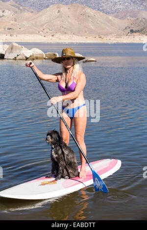 Una donna anziana su supporto su paddle boards sul Lago Isabella vicino a Bakersfield, est della California valle centrale che è a meno di 13% di capacità dopo quattro anni di siccità devastanti. Il serbatoio è scesa così bassa che il livello di acqua è al di sotto del tubo di uscita. Foto Stock