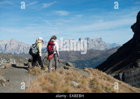 Frau und tipo wandern auf Schotterweg - donna e bambini escursioni sulla via alpina Foto Stock
