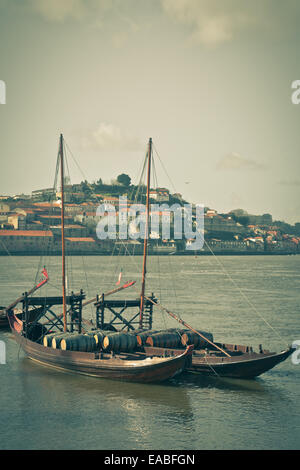 Botti da vino in una vecchia barca in porto. Verticale shot filtrato Foto Stock