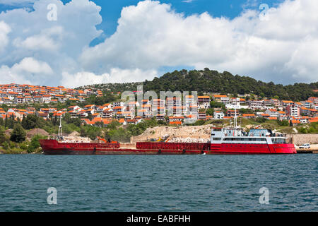 Chiatta rosso con pietre e sabbia vicino a un fiume Coast Foto Stock