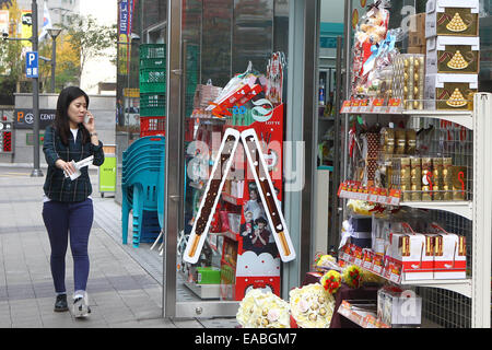 Seoul, Corea del Sud. Xi Nov, 2014. Una donna cammina davanti a un negozio di alimentari a Seul, Corea del Sud, nov. 11, 2014. Pepero giorno viene celebrata ogni anno il 9 novembre 11 in Corea del Sud, con negozi che vendono cioccolato pepero bastoni e singole persone che stanno cercando di trovare la loro il signor o la signora diritti. © Yao Qilin/Xinhua/Alamy Live News Foto Stock