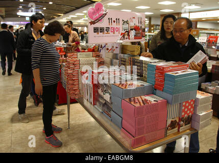 Seoul, Corea del Sud. Xi Nov, 2014. Persone selezionare pepero bastoncini di cioccolato presso un negozio di alimentari a Seul, Corea del Sud, nov. 11, 2014. Pepero giorno viene celebrata ogni anno il 9 novembre 11 in Corea del Sud, con negozi che vendono cioccolato pepero bastoni e singole persone che stanno cercando di trovare la loro il signor o la signora diritti. © Yao Qilin/Xinhua/Alamy Live News Foto Stock