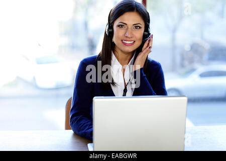 Felice bella call-center assistente presso la scrivania Foto Stock