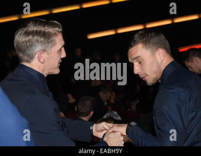 Sony Center di Potsdamer Platz, Berlin, Germania. Decimo Nov, 2014. La Germania Bastian SCHWEINSTEIGER (L) e Lukas Podolski frequentare il mondo premiere del film 'Die Mannschaft' (lit. " Il team') al Sale del Cinestar di movie theatre al Sony Center di Potsdamer Platz, Berlin, Germania, 10 novembre 2014. Bastian SCHWEINSTEIGER (L) e l'ex capitano Philipp Lahm (R) tenere il trofeo in prima fila, Mesut Oezil e Mario Goetze stand alla loro destra. Il film è il documentario ufficiale della FIFA Soccer World Championship 2014 in Brasile. Foto: Jens KALAENE/dpa/Alamy Live News Foto Stock