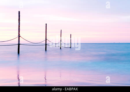 Una spiaggia fotografato durante un bel tramonto (lunga esposizione), regione del Mare del Nord, Germania. Foto Stock